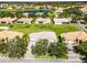 An aerial view of the home showcases its tile roof, landscaping, and a neighborhood lake at 3643 Weatherfield Dr, Kissimmee, FL 34746