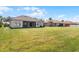 Large backyard with lush green grass and views of the home's tile roof and screened in patio at 3643 Weatherfield Dr, Kissimmee, FL 34746