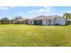Large backyard with lush green grass and views of the home's tile roof and screened in patio at 3643 Weatherfield Dr, Kissimmee, FL 34746