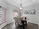 Bright dining room with stylish light fixture, wood floors, and decorative window treatments at 3643 Weatherfield Dr, Kissimmee, FL 34746