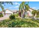 Charming home featuring a lush green lawn, palm trees, and beautiful landscaping at 3643 Weatherfield Dr, Kissimmee, FL 34746
