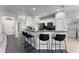 Modern kitchen with black appliances, bar seating, and views into the entry and utility area at 3643 Weatherfield Dr, Kissimmee, FL 34746