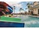 Resort-style pool area with a waterslide, surrounded by palm trees and comfortable seating for ultimate relaxation and fun at 3643 Weatherfield Dr, Kissimmee, FL 34746