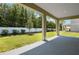 This covered back patio overlooks a lawn and a white fence lined with mature trees at 3724 Deer Ridge Dr, Mount Dora, FL 32757