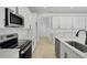 Spacious kitchen with stainless steel appliances, white cabinets, and an open layout design at 3724 Deer Ridge Dr, Mount Dora, FL 32757