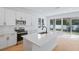 Bright kitchen featuring white cabinets, stainless steel appliances, an island, and backyard view at 3732 Deer Ridge Dr, Mount Dora, FL 32757