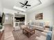 Bright living room featuring modern ceiling fan, neutral walls, and cozy seating arrangement with kitchen view at 7510 Seven Eagles Way # 7510, Reunion, FL 34747