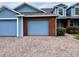 Charming blue townhome with brick accents, two-car garage and paved driveway at 3480 Home Town Ln, Saint Cloud, FL 34769