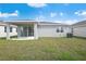 Backyard featuring a covered patio, grass, and the exterior of the home at 652 Hennepin Loop, Lake Wales, FL 33898