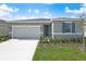 Inviting one-story home featuring a well-manicured lawn and a pristine, two-car garage at 652 Hennepin Loop, Lake Wales, FL 33898