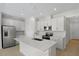 Modern kitchen with stainless steel appliances, white cabinetry, and an island with a sink at 652 Hennepin Loop, Lake Wales, FL 33898