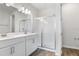 Modern bathroom showcasing double sinks, a glass-enclosed shower, and stylish wood-look tile floors at 656 Hennepin Loop, Lake Wales, FL 33898