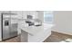 Bright kitchen with stainless steel appliances, white cabinets, and a large center island at 656 Hennepin Loop, Lake Wales, FL 33898
