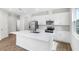 Bright kitchen with stainless steel appliances, white cabinets, and a large center island at 656 Hennepin Loop, Lake Wales, FL 33898