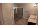 Bathroom boasts a glass-enclosed shower with stone flooring and a double vanity at 1222 Castlevecchio Loop, Orlando, FL 32825