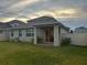 Exterior shot showcasing the backyard with covered patio, fence, and lawn at 1222 Castlevecchio Loop, Orlando, FL 32825