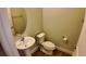 Cozy half bathroom featuring a pedestal sink and toilet at 1222 Castlevecchio Loop, Orlando, FL 32825