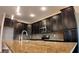 Close-up of the kitchen featuring granite countertops, dark cabinets, tile backsplash, stainless steel appliances, and modern lighting at 1222 Castlevecchio Loop, Orlando, FL 32825