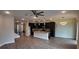 Open-concept kitchen featuring dark cabinets, granite countertops, stainless steel appliances, wood floors, and pendant lighting at 1222 Castlevecchio Loop, Orlando, FL 32825