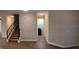 Open-concept living space with wood floors, recessed lighting, an accent wall, staircase, and a peek into the laundry area at 1222 Castlevecchio Loop, Orlando, FL 32825