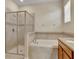 Bathroom featuring soaking tub with tile surround and separate glass shower with neutral color palette at 1569 Thetford Cir, Orlando, FL 32824