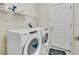 Bright laundry room features modern Whirlpool washer and dryer and convenient shelving at 1569 Thetford Cir, Orlando, FL 32824