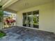 Covered patio with sliding glass doors and view of the well manicured backyard at 1569 Thetford Cir, Orlando, FL 32824