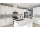 Bright kitchen with white cabinets, stainless steel appliances, quartz counters, and a large island at 3824 Deer Ridge Dr, Mount Dora, FL 32757