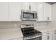 Well-equipped kitchen featuring stainless steel appliances, a microwave, and a sleek electric range at 3824 Deer Ridge Dr, Mount Dora, FL 32757