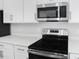 Stainless steel appliances and white countertops in kitchen at 520 Summit River Dr, Apopka, FL 32712