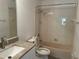 Full bathroom with a granite vanity top, toilet, and tiled shower over tub at 14716 Yorkshire Run Dr, Orlando, FL 32828