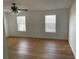 Bedroom with light wood floors, two windows, and a ceiling fan at 14716 Yorkshire Run Dr, Orlando, FL 32828
