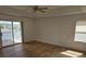 Sunny main bedroom featuring tray ceiling, sliding glass doors to balcony, and wood-look flooring at 14716 Yorkshire Run Dr, Orlando, FL 32828