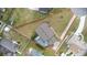 Expansive aerial view showcasing the house on a corner lot, mature trees, lawn, and a screened-in pool at 1855 Cavalier Ct, Kissimmee, FL 34744