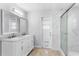 Bright bathroom featuring a double vanity, stylish mirrors, and a sleek glass-enclosed shower at 1855 Cavalier Ct, Kissimmee, FL 34744