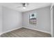 A modest bedroom includes a ceiling fan, wood-look flooring, and a window with exterior views at 1855 Cavalier Ct, Kissimmee, FL 34744