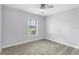 Bright bedroom features wood-look flooring, a ceiling fan, and a window with exterior views at 1855 Cavalier Ct, Kissimmee, FL 34744