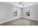 A bedroom with two windows that offer natural light and wood-look flooring at 1855 Cavalier Ct, Kissimmee, FL 34744