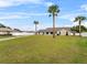 Charming single-story home featuring a lush lawn and mature palm trees, adding curb appeal at 1855 Cavalier Ct, Kissimmee, FL 34744