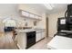 Open kitchen with black appliances flowing to the dining and living area at 3151 Britannia Blvd # C, Kissimmee, FL 34747