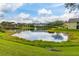 Picturesque pond view with lush green surroundings and building reflections for a tranquil setting at 3151 Britannia Blvd # C, Kissimmee, FL 34747
