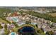 High aerial view showcases the property's proximity to a pond, pool, tennis courts and green spaces at 8716 Rain Forest Pl # D, Kissimmee, FL 34747