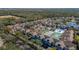 Panoramic aerial view of the community with colorful buildings, tennis court and a beautiful treeline at 8716 Rain Forest Pl # D, Kissimmee, FL 34747