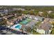 Expansive aerial view of community featuring a pool, tennis courts, and well-maintained colorful buildings at 8716 Rain Forest Pl # D, Kissimmee, FL 34747