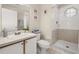 Well-lit bathroom with a vanity, toilet, and tiled shower featuring an octagonal window at 8716 Rain Forest Pl # D, Kissimmee, FL 34747