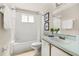 Bright bathroom features a tub and shower, vanity, and neutral color scheme at 8716 Rain Forest Pl # D, Kissimmee, FL 34747