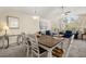 Open-concept dining room with a large window and a rustic wood table at 8716 Rain Forest Pl # D, Kissimmee, FL 34747
