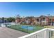 View of tennis court and swimming pool in front of condos, on a sunny day at 8716 Rain Forest Pl # D, Kissimmee, FL 34747