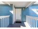 Charming entryway featuring a white front door with a covered porch and blue siding at 8716 Rain Forest Pl # D, Kissimmee, FL 34747