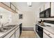 Functional kitchen features white cabinetry and modern black appliances at 8716 Rain Forest Pl # D, Kissimmee, FL 34747